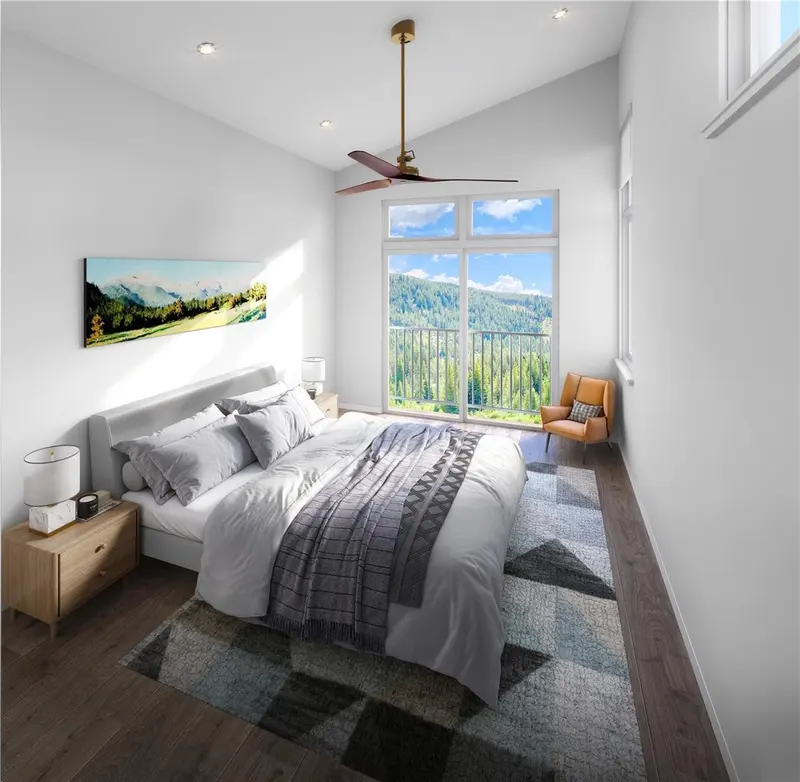 Modern bedroom with a large bed, geometric rug, and wooden nightstands. Large windows reveal a scenic mountain view, and an orange chair sits by the window. Ceiling fan and landscape artwork add stylish touches.