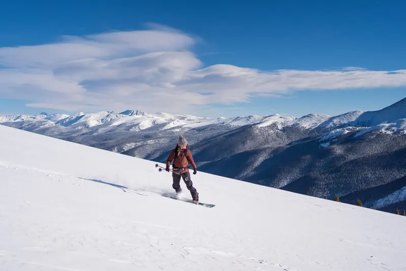 Candice De snowboarding down a sunny Colorado slope