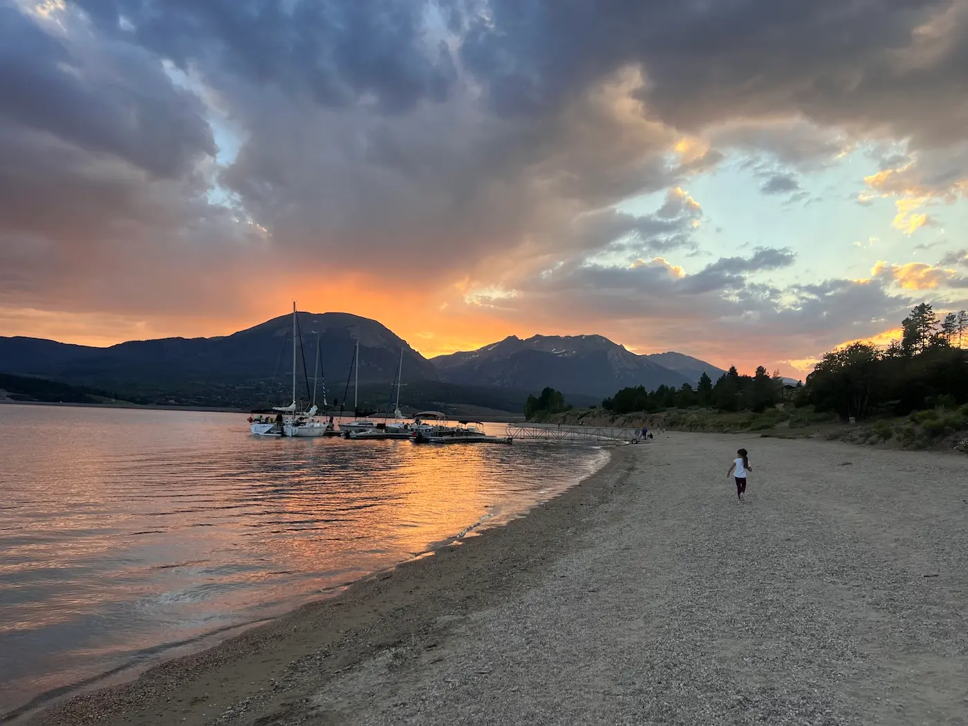 Sunset over Lake Dillon with sailboats moored along the shore