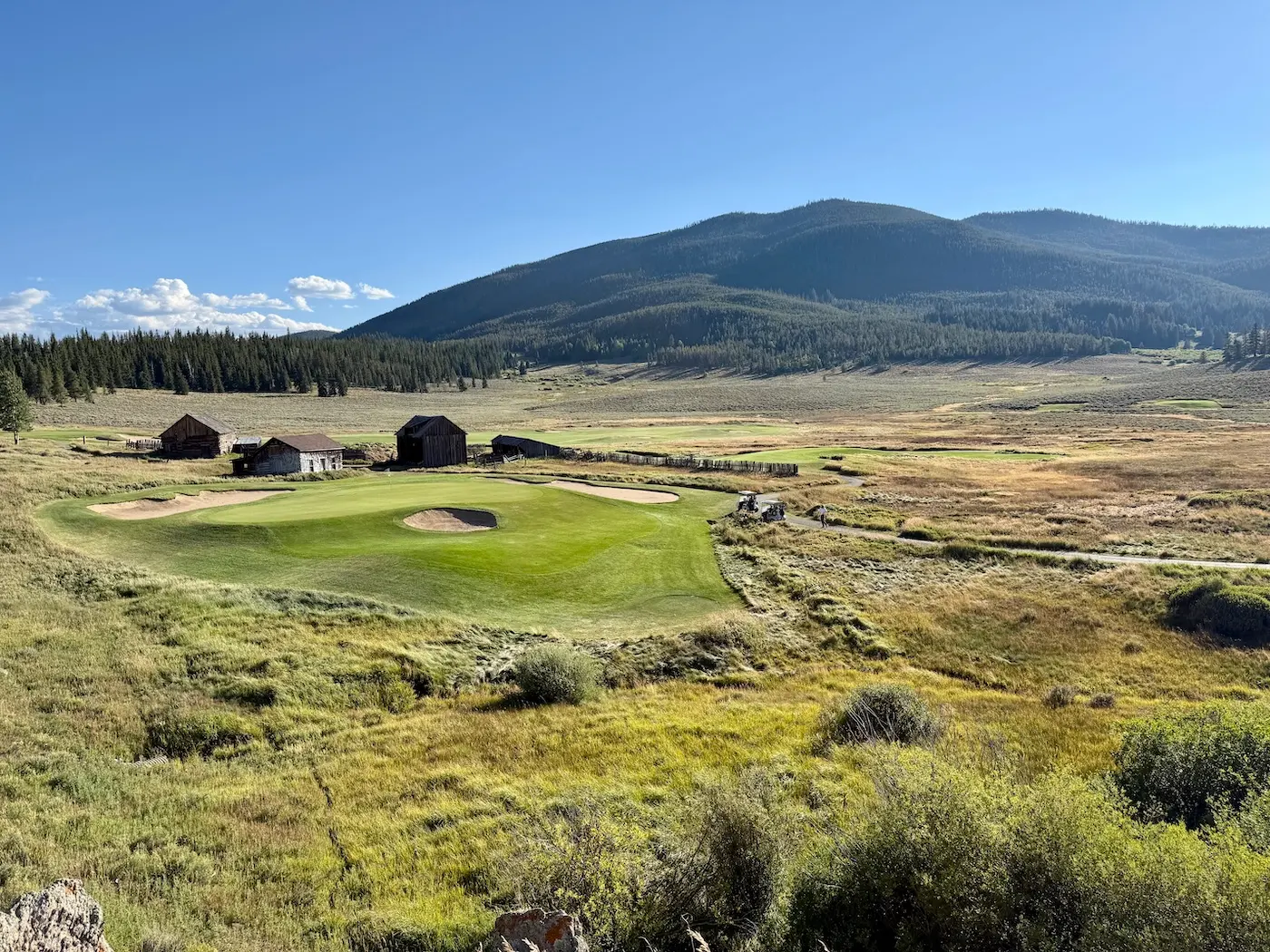 Keystone Ranch golf course and meadow with forested mountains behind